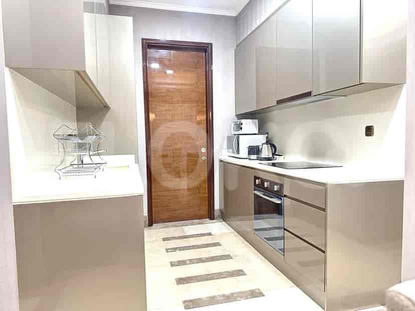 Modern kitchen with wooden door and integrated appliances.