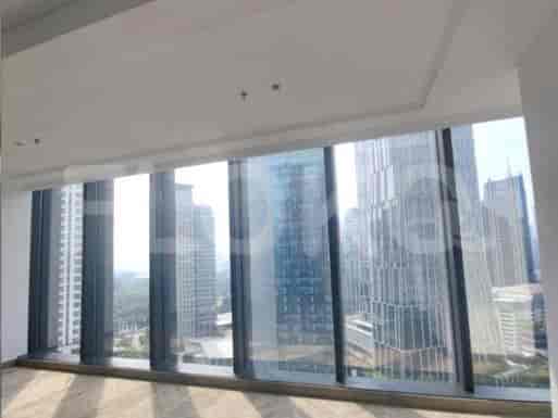 An empty room with large windows showcasing a city view.