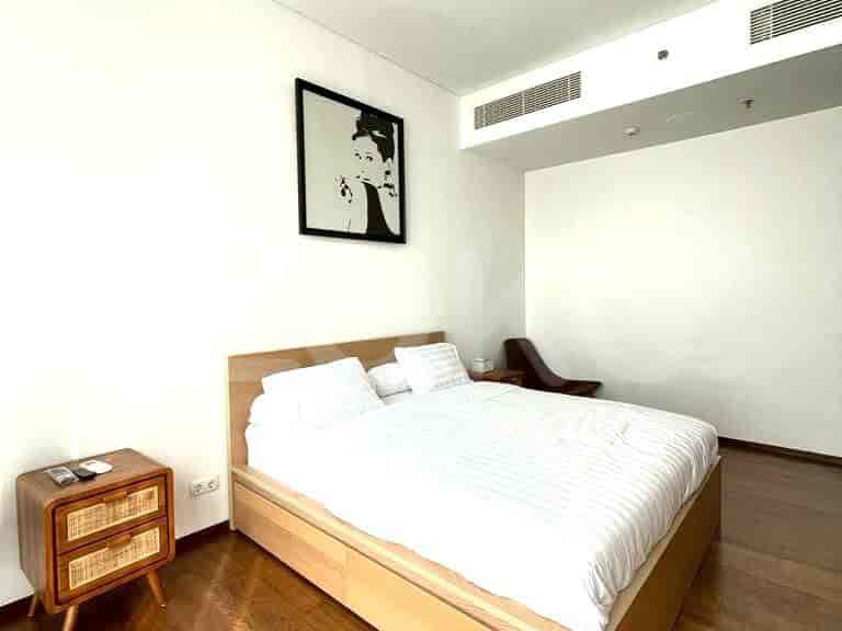 Bedroom featuring a double bed, bedside table, and artwork.