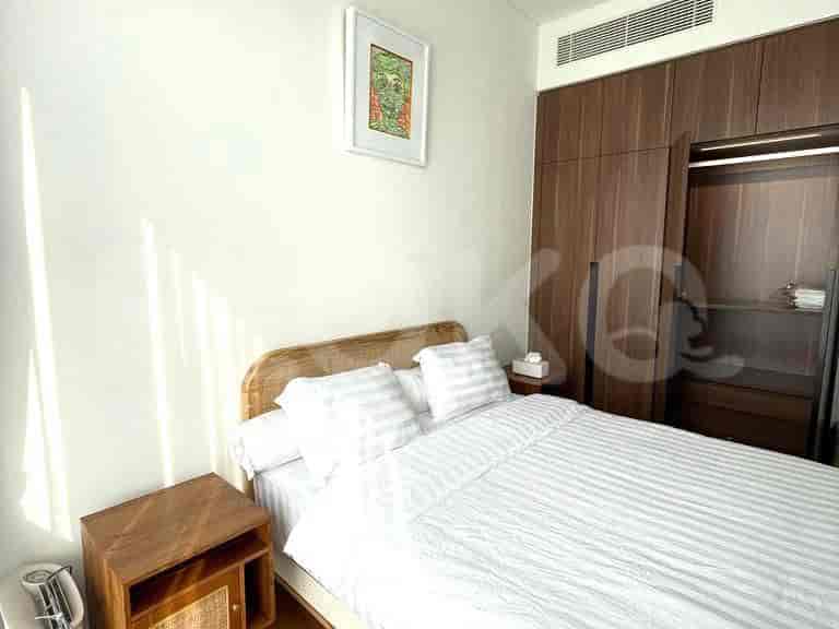Bedroom with a double bed, artwork, wooden nightstand, and a closet.