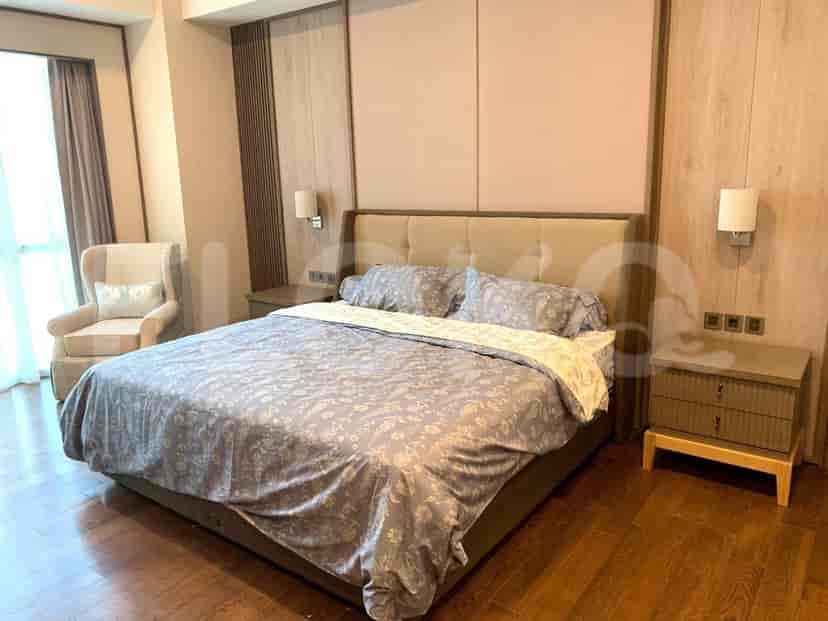 A spacious bedroom featuring a king-size bed, elegant bedside tables, and warm wooden flooring.
