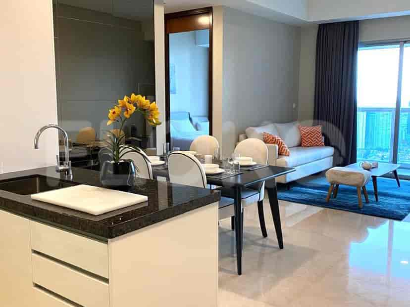 A view showing the dining area, open kitchen, and a partial view of the living room.