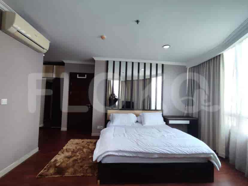Bedroom with a large bed, decorative wall panels, and a door to the ensuite.