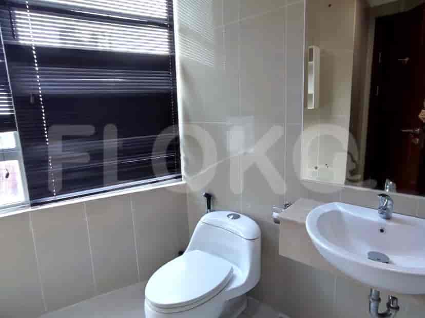 Bathroom with a toilet, sink, and window with blinds.