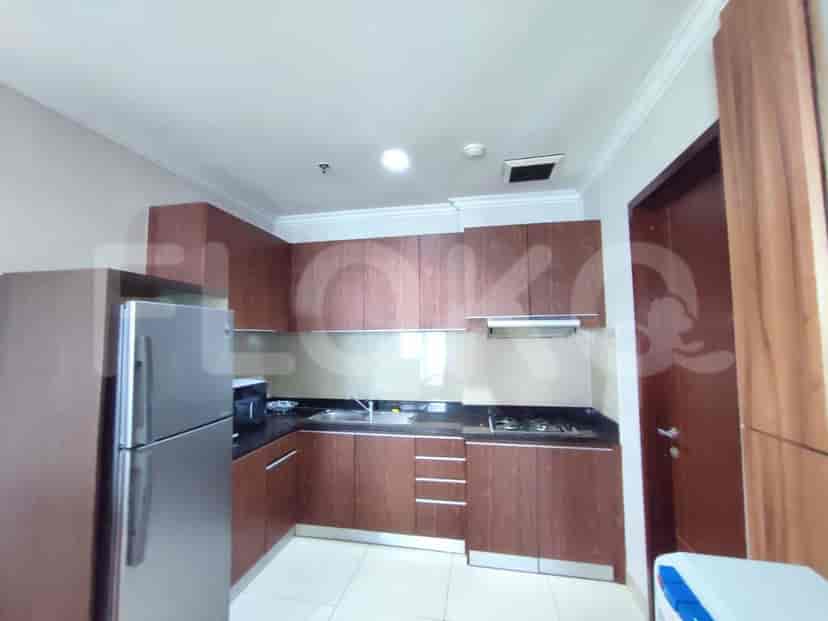 Modern kitchen with wooden cabinets, stainless steel appliances, and a black countertop.