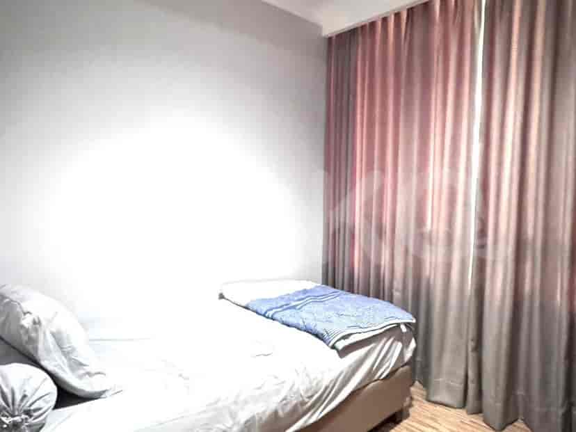 A simple bedroom featuring a bed and curtains.