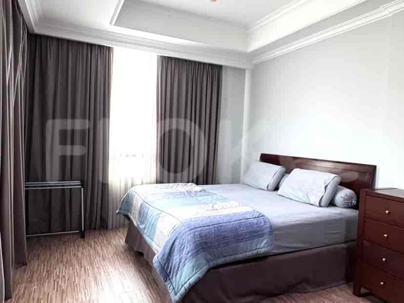 A well-lit bedroom with a bed and a chest of drawers.