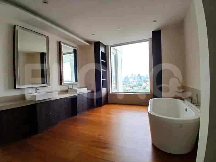Kamar mandi luas dengan bak mandi, wastafel ganda, dan pemandangan kota.