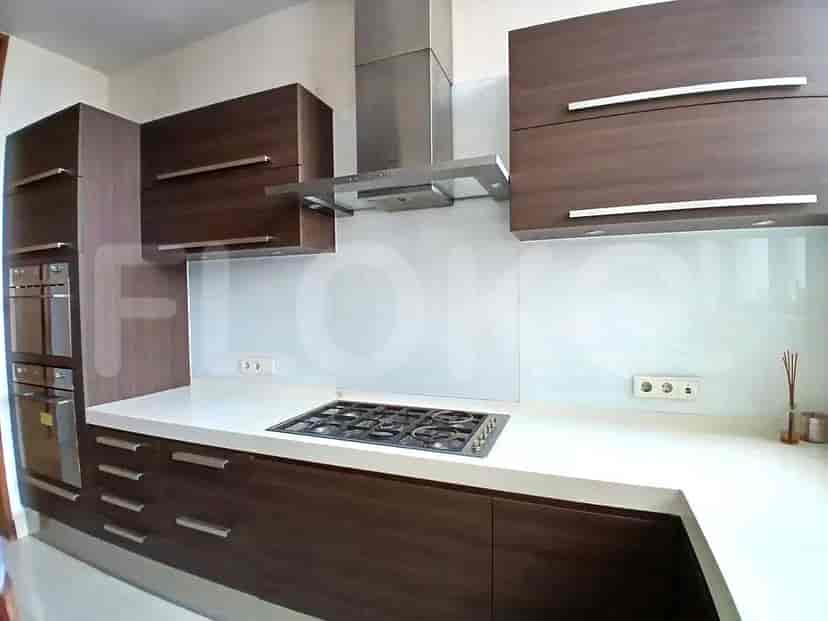 Dapur modern dengan lemari kayu gelap, kompor gas, dan peralatan stainless steel.