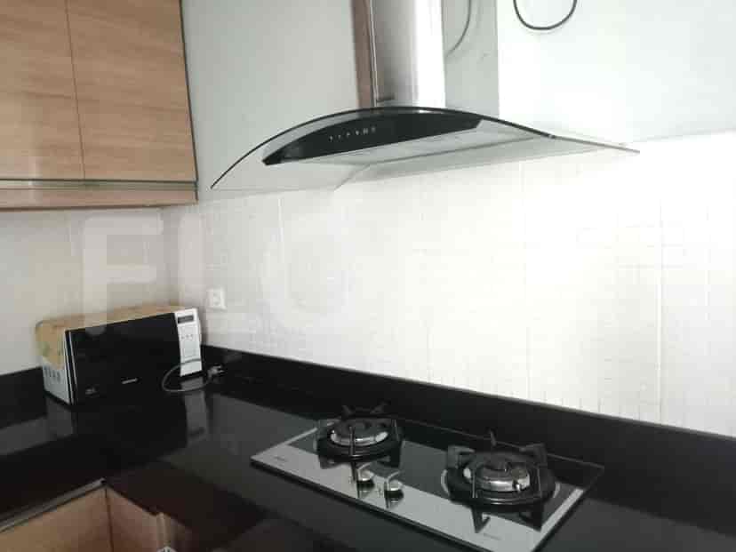 Modern kitchen with stainless steel appliances and black countertop.