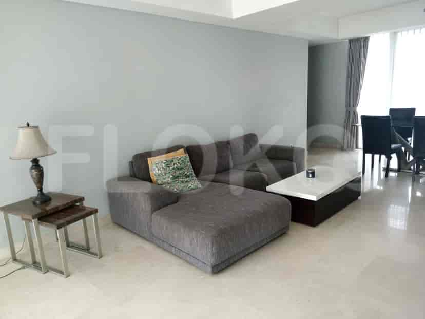 Modern living room with a grey sectional sofa, coffee table, and dining area.