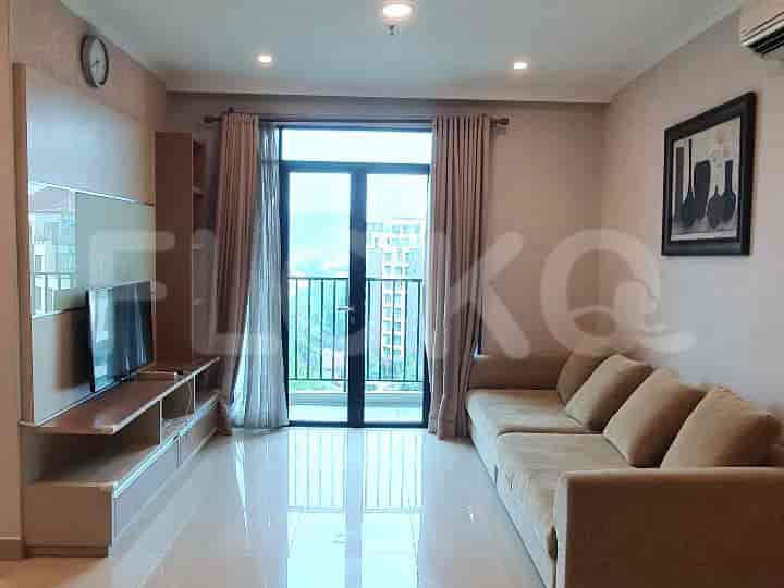 Ruang tamu modern dengan sofa abu-abu, TV yang dipasang di dinding, dan akses balkon.
