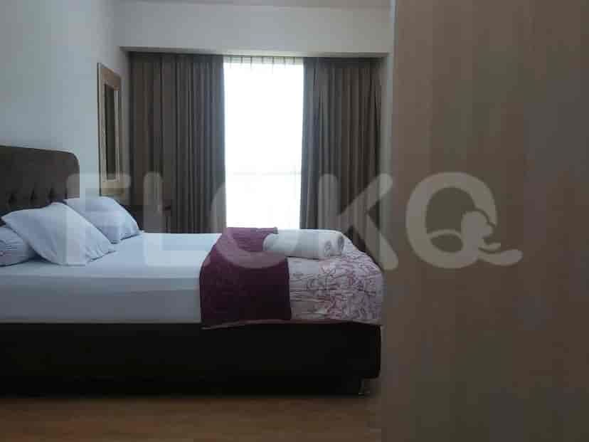 A bedroom featuring a double bed with a maroon runner, window with curtains, and a framed mirror.