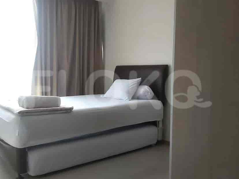 A bedroom with a single bed, pull-out trundle, and window.