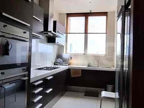 Dapur modern dengan lemari gelap dan meja putih.