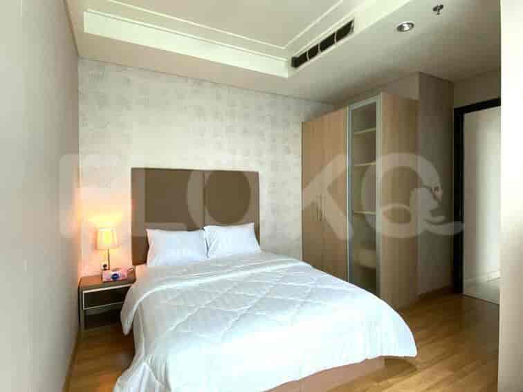 Kamar tidur kedua yang menampilkan tempat tidur queen, meja nakas, dan jendela besar.