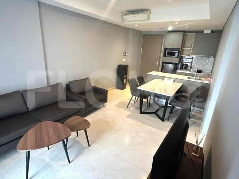 Modern open-concept living and kitchen area featuring a sofa, dining set, and a compact kitchen setup.