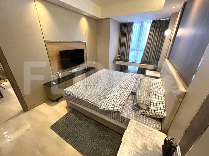 A modern bedroom featuring a king-sized bed with a smart TV and a neutral color scheme.