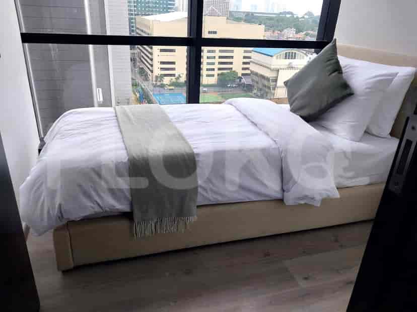 A well-lit bedroom with a bed near a large window offering a city view.