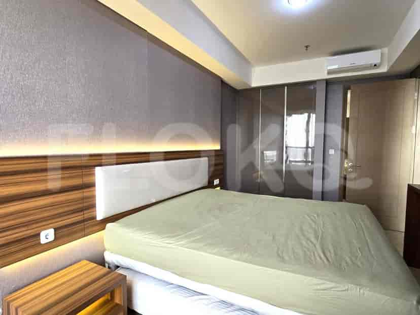 A contemporary bedroom featuring a bed with a cushioned headboard and built-in lighting.