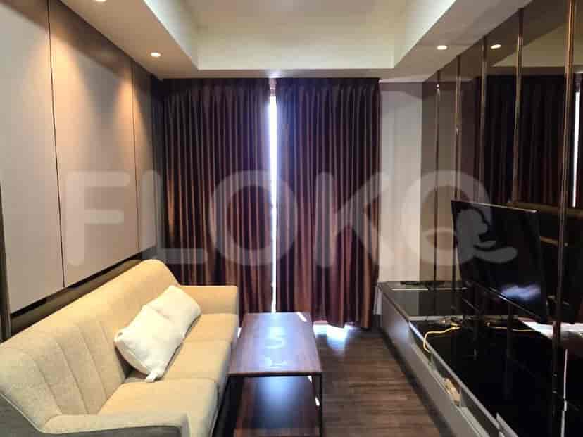 A living room with a beige sofa, wooden coffee table, and floor-to-ceiling brown curtains.