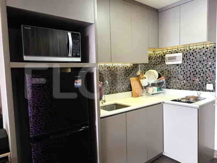 A modern kitchen featuring cabinets, a microwave, and a refrigerator.