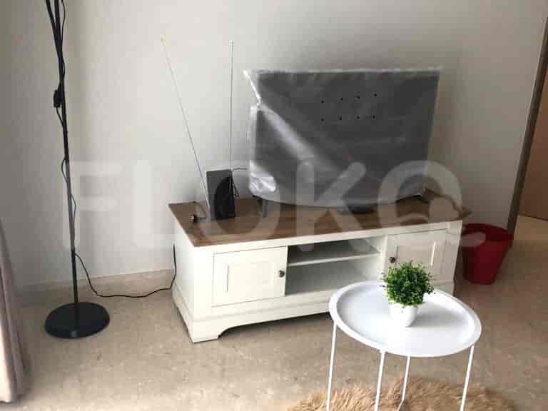 Living room with television, small table, and floor lamp.