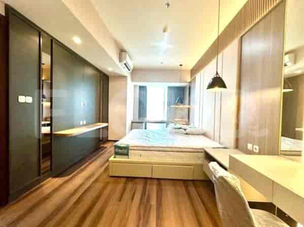 Kamar tidur dengan tempat tidur ganda, area meja, dan ruang penyimpanan yang luas.