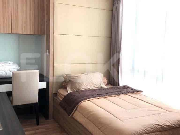 A single bed in a bedroom with a desk area.
