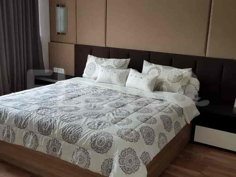 A bedroom with a bed, two nightstands, and a large headboard.
