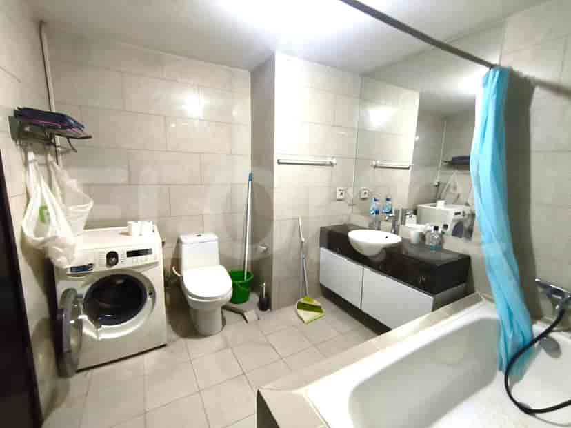 A modern bathroom with a washing machine, toilet, and bathtub.
