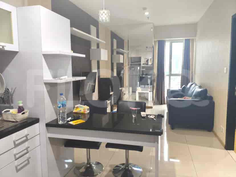 Modern kitchen and living area with a black dining table, white cabinets, and a view of the city through a large window.