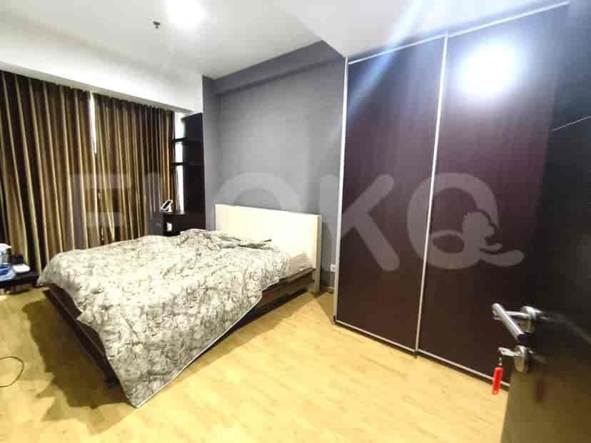 Contemporary bedroom featuring a bed with a patterned comforter, large wardrobe, and hardwood flooring.