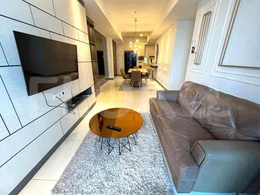 A modern living room with a brown leather sofa, round coffee table, and wall-mounted TV.