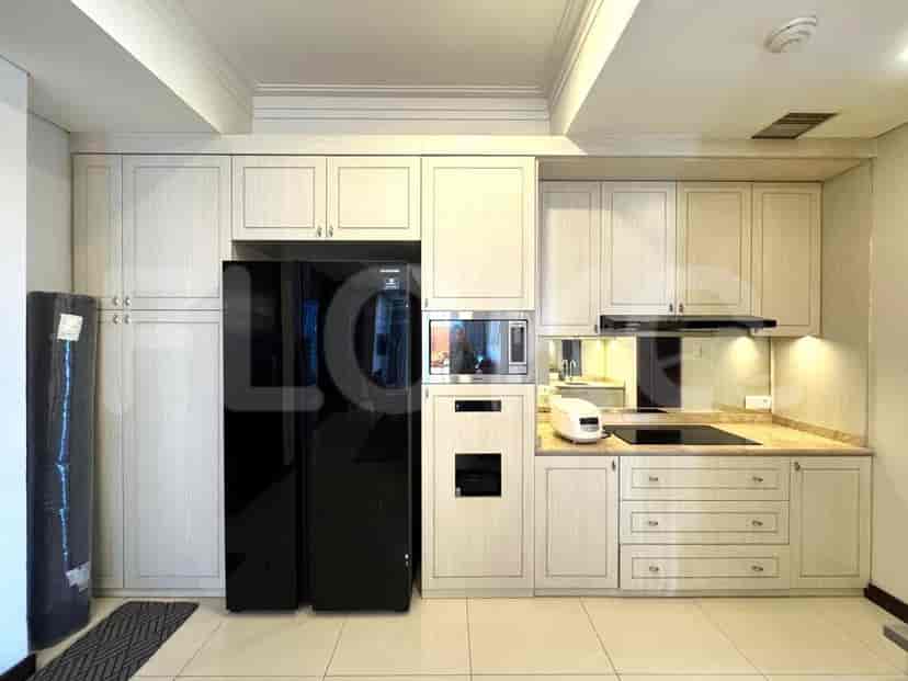 A modern kitchen featuring white cabinets, a black refrigerator, and built-in appliances.