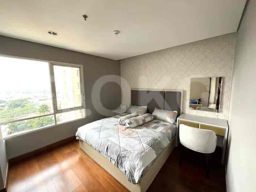 A stylish bedroom with a bed, vanity, and large window.