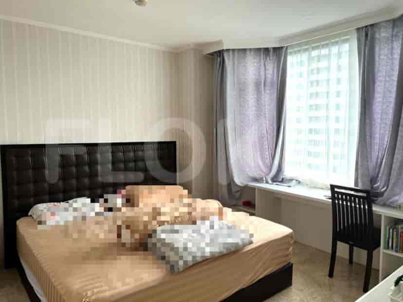A bedroom with a bed, curtains, and a desk.