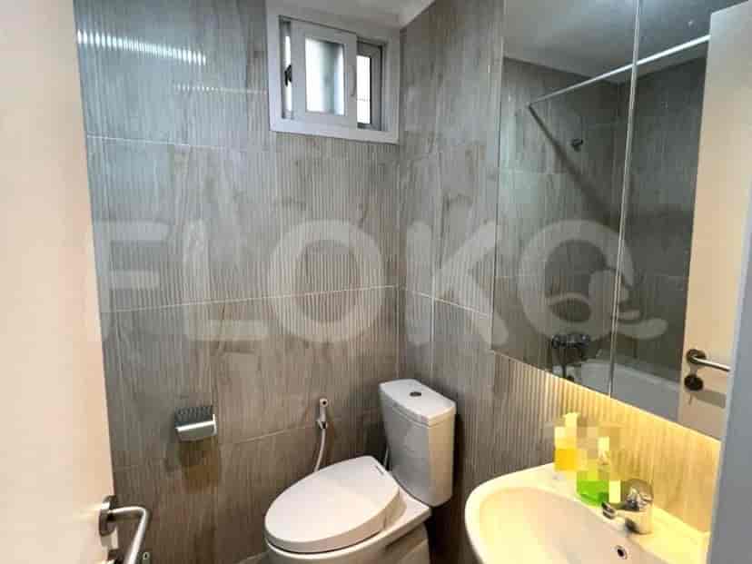 A bathroom with a toilet, sink, and mirror.