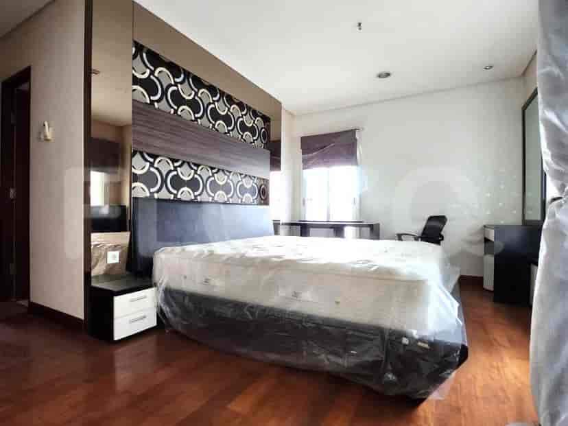 A bedroom with a bed and decorative headboard.