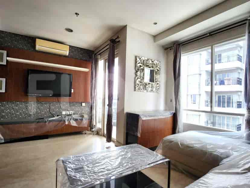 Living room with TV, sofa, and large windows.