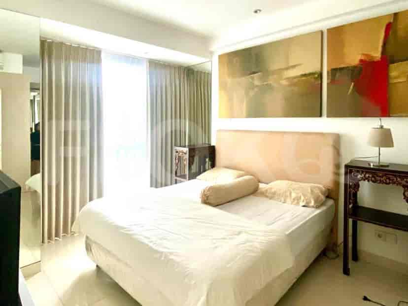 Another view of the bedroom featuring a large bed, bedside tables, and artwork.