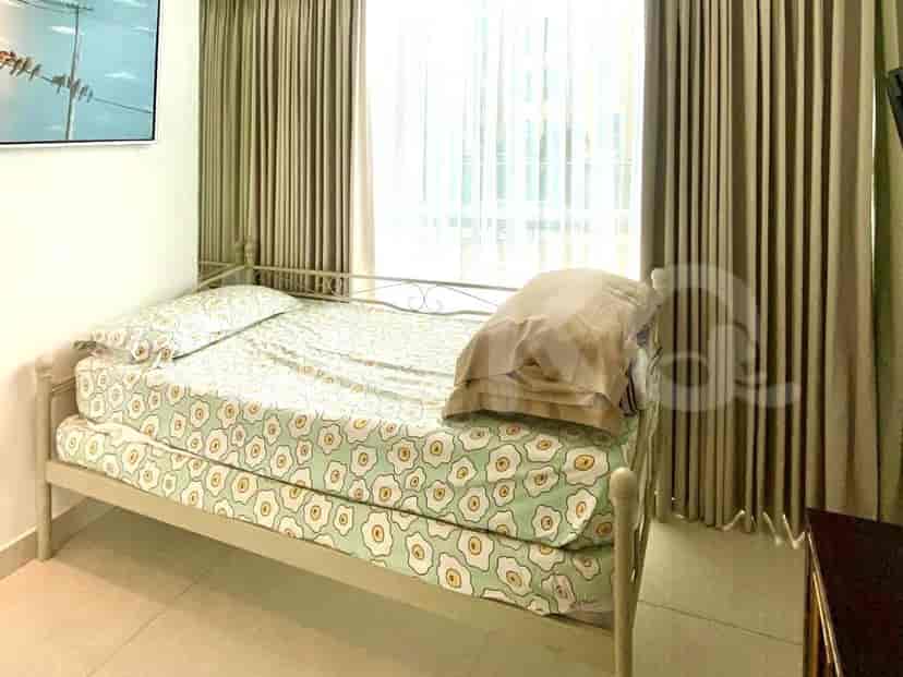 A small bedroom with a twin bed and patterned bedding.