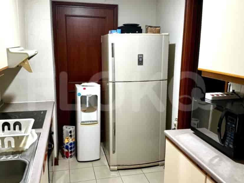 A kitchen with a refrigerator, stove and water dispenser.