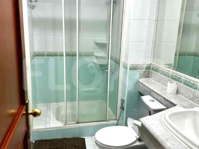 A bathroom with a shower stall, a toilet and a sink.