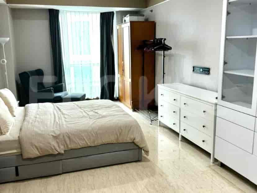 A bedroom with a bed, a wardrobe, and a dresser.