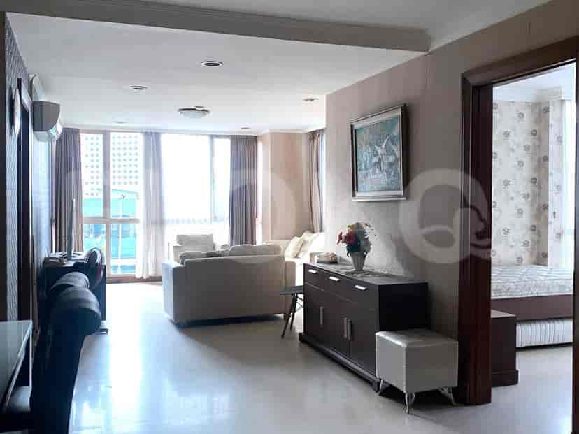 Living area showcasing a sofa, a TV, a side table and a wall-mounted mirror.