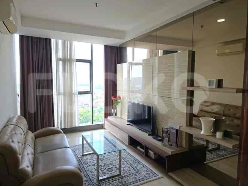 Modern living room with a sofa, TV, and large windows.