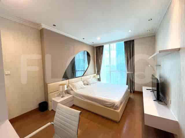 A modern bedroom with a large bed, a mirror, and a desk.