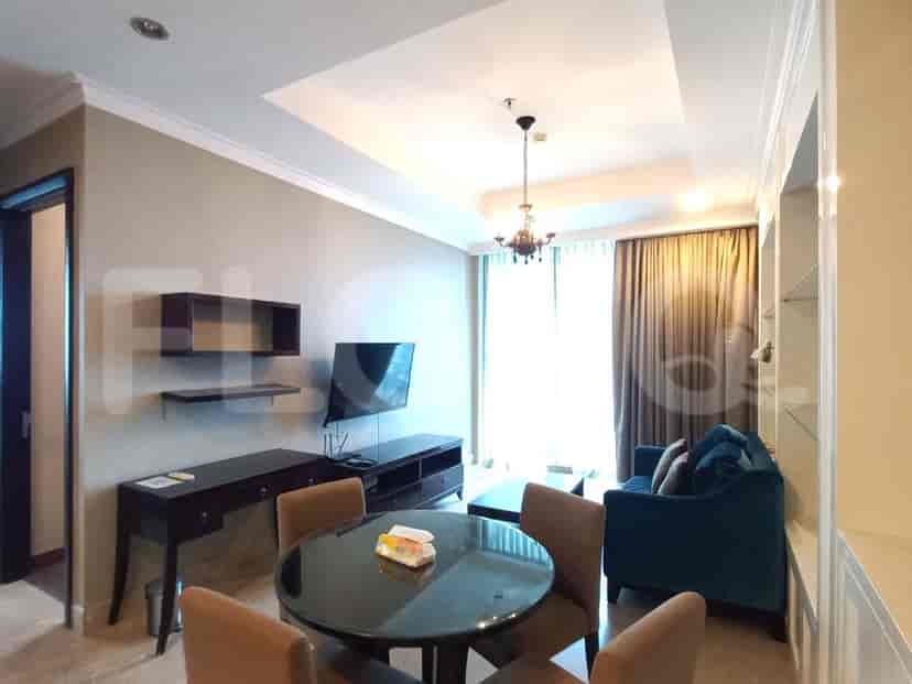 A stylish living room featuring a round dining table, comfortable sofa, and a mounted TV.