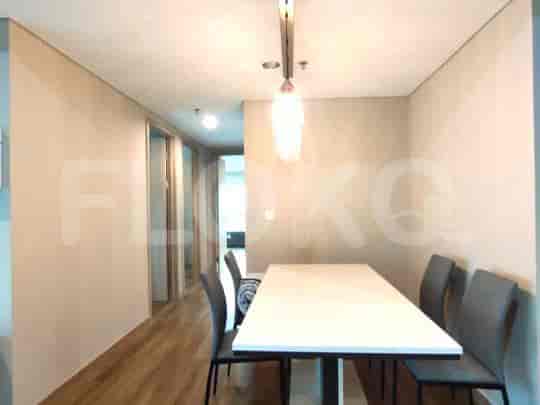 Dining area with a long table and chairs, featuring modern design and ample natural light.